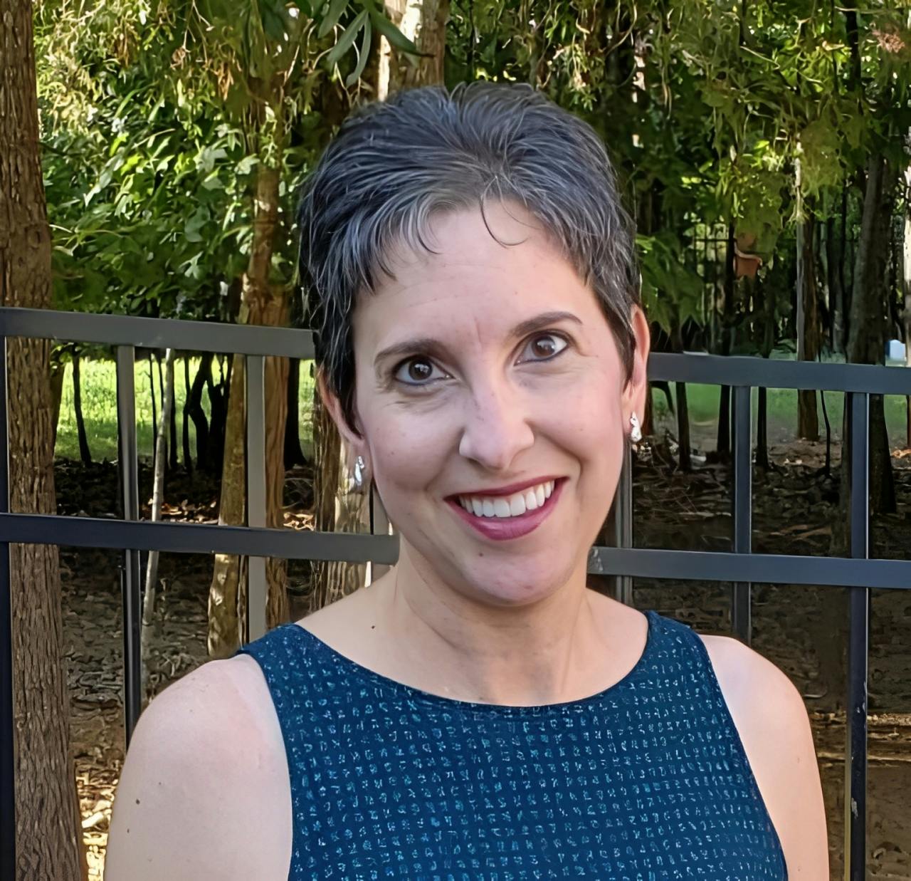 Woman with short hair standing outside, smiling