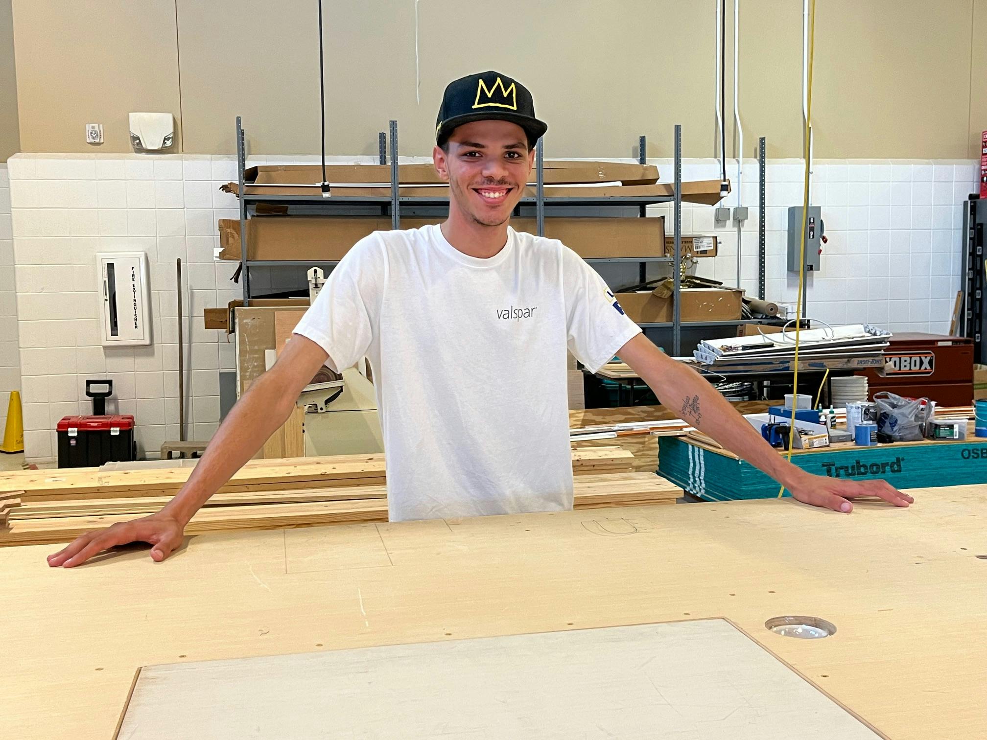Man standing in classroom with ballcap on
