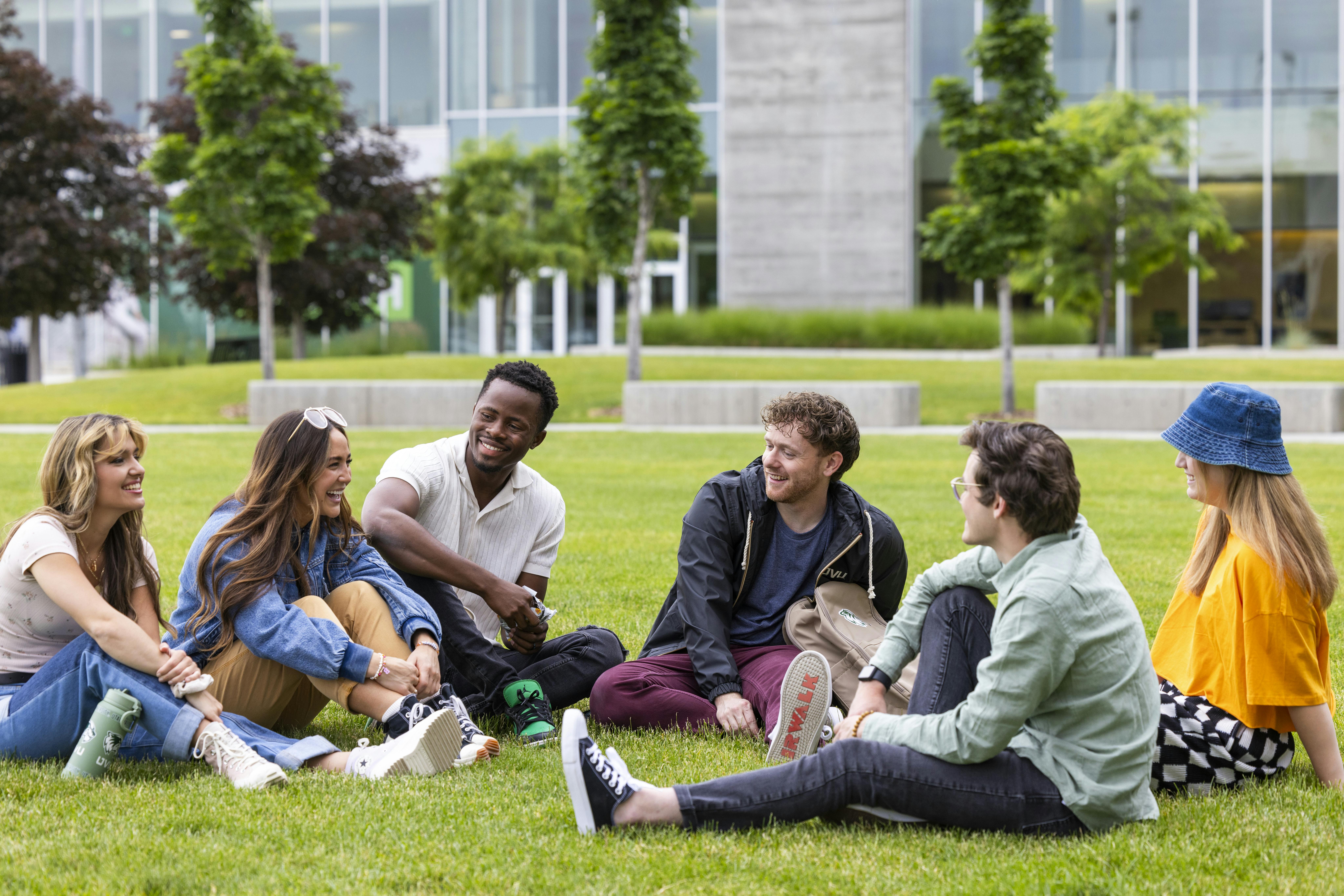 Students lounging on the grass talking