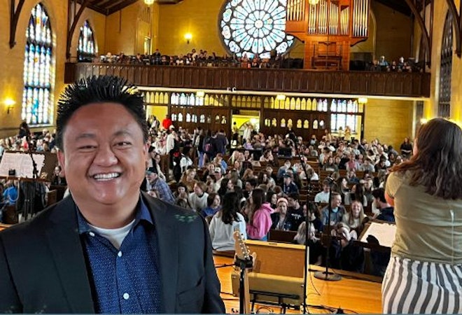 Image of Felix Theonugraha looking directly into the camera with a full Dimnet Chapel in the background 