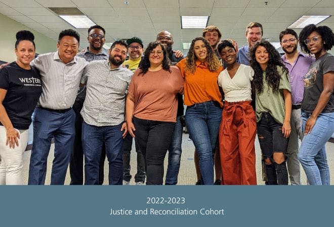 Image of the 14 members seminary faculty and students looking standing shoulder to shoulder smiling at the camara